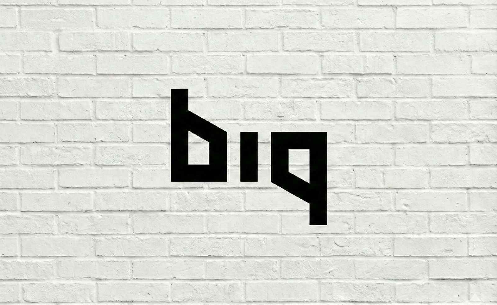 Logo BIQ na bílém cihlovém zdivu